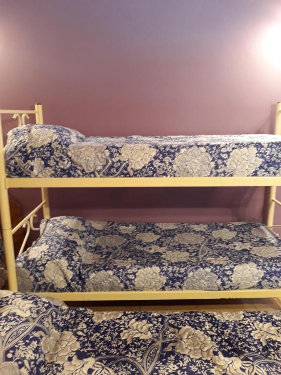 2 literas en una habitación con sábanas azules y blancas en Monoambiente en Tandil