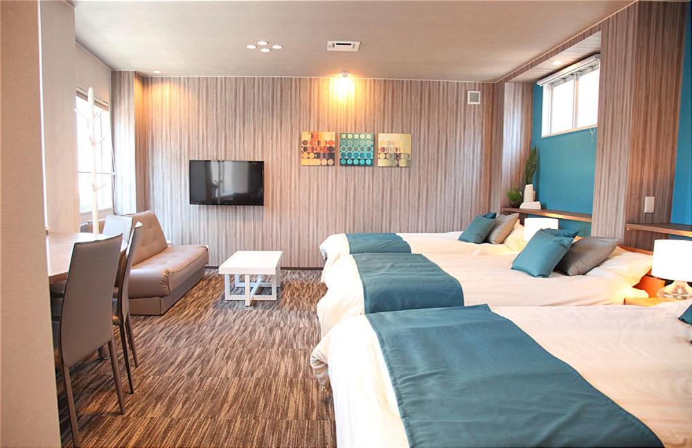 pokój hotelowy z 2 łóżkami i telewizorem z płaskim ekranem w obiekcie Tanimachi 4chome 5F w Osace