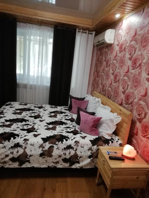 ヘルソンにある2 - bedrooms apartmentのベッドルーム(ピンクの枕が付いた黒と白のベッド付)