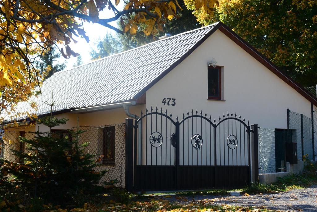 una pequeña casa blanca con una puerta negra en Burg nad Banskou Štiavnicou, en Štiavnické Bane