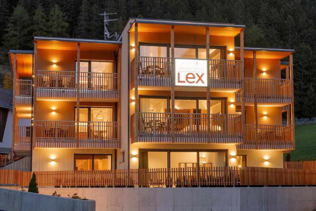 an apartment building with a lit up sign on it at Residence Lex in Resia