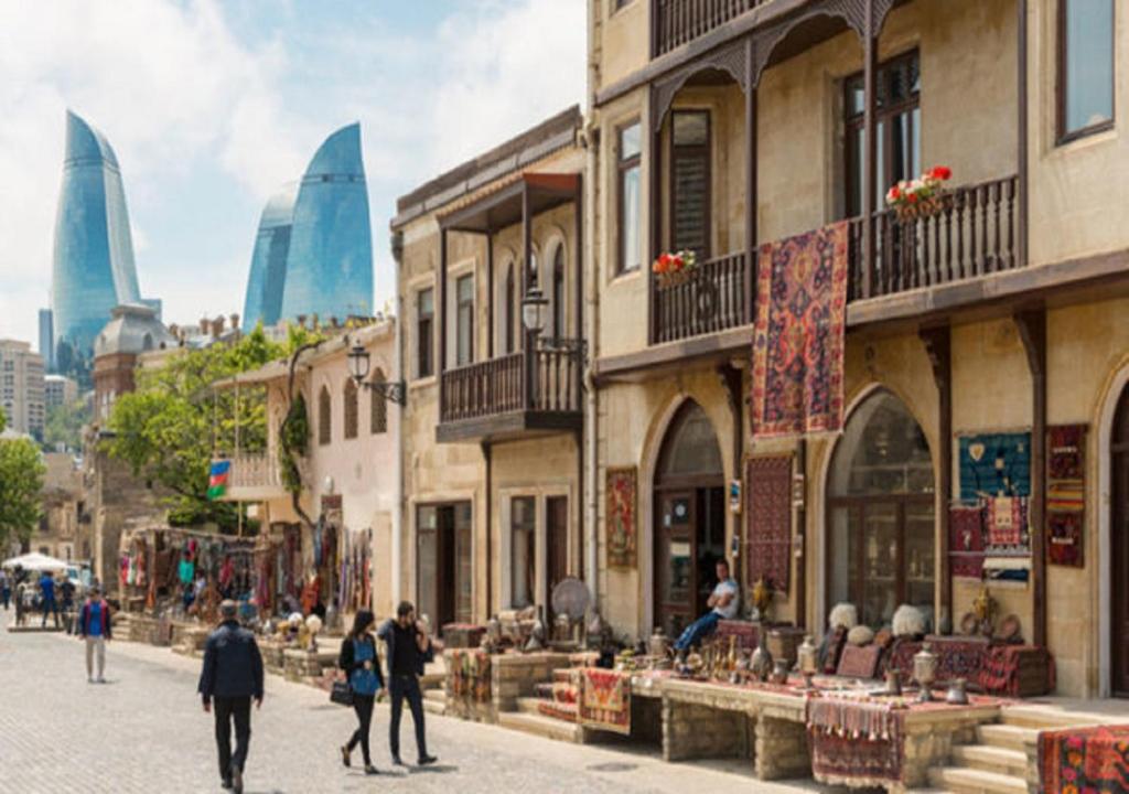 un gruppo di persone che camminano per una strada con edifici di Квартира в Ичери шехер a Baku