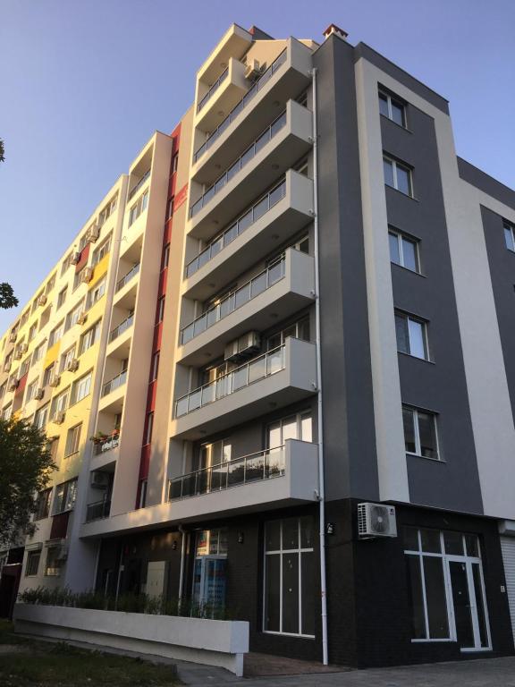 um edifício de apartamentos com um edifício amarelo e cinzento em AirLuxApartament em Burgas