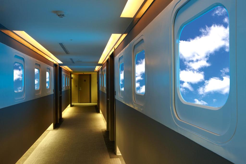 een gang van een trein met een blauwe lucht door ramen bij Ximen Airline Hotel in Taipei
