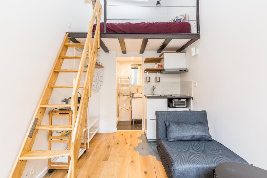 Cette chambre comprend une mezzanine et un canapé. dans l'établissement Le Loft du Marais, à Paris