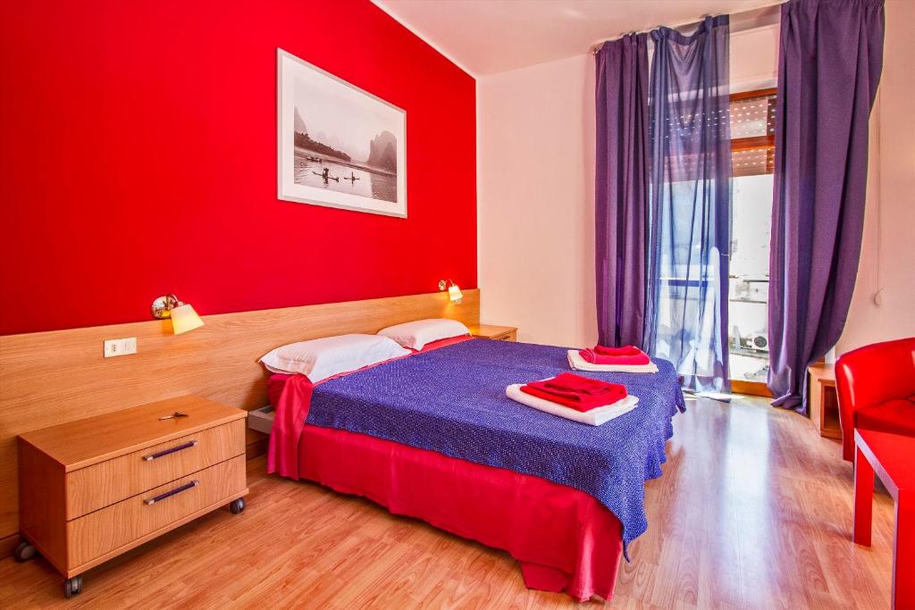 1 dormitorio con cama y pared roja en Mamma Sisi, en Lecce