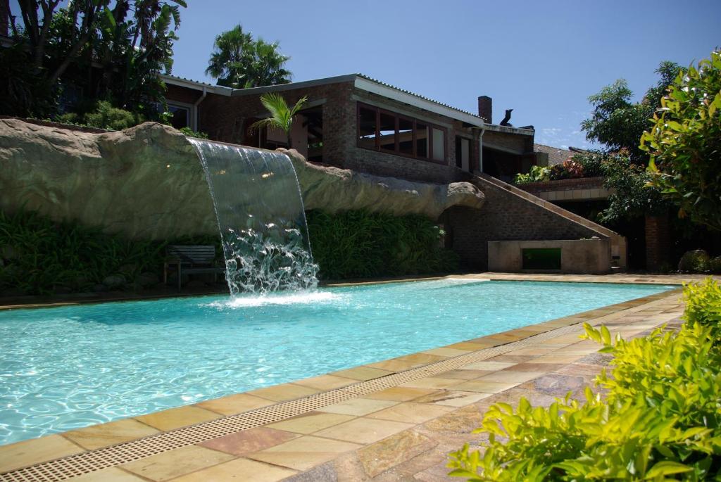 a swimming pool with a water fountain at Columbus Guest House in Nelspruit