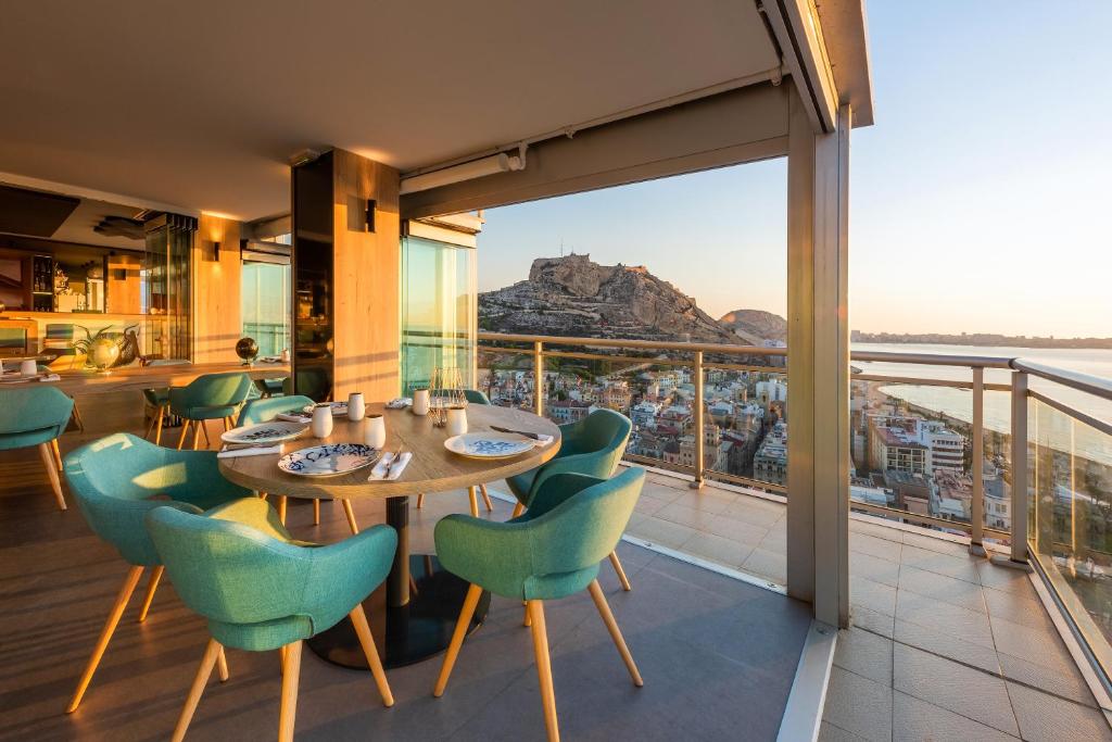 ein Esszimmer mit einem Tisch und Stühlen auf dem Balkon in der Unterkunft Hotel Alicante Gran Sol, affiliated by Meliá in Alicante