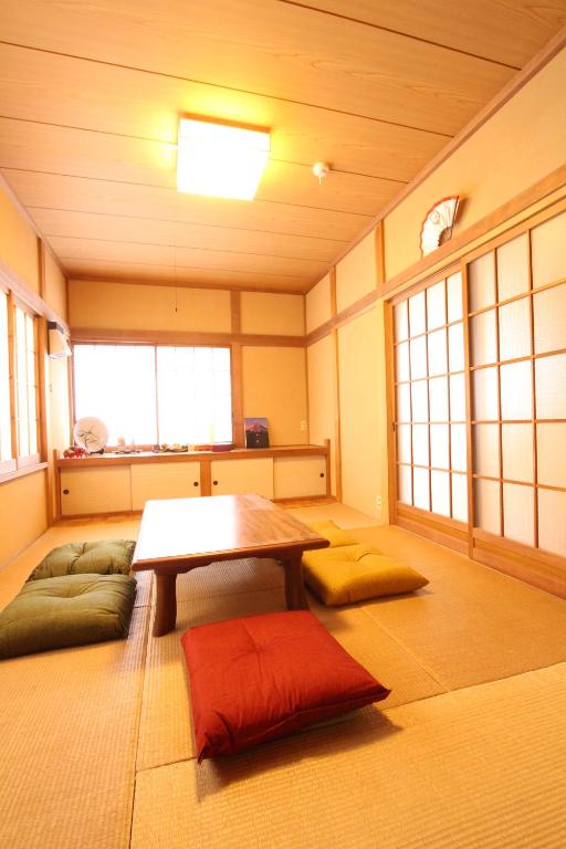 a room with a table and some pillows in it at Gran kodachi in Fujikawaguchiko