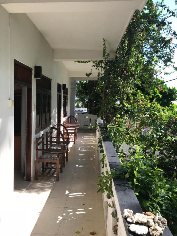 a porch with benches and plants on a house at Unawatuna Beach Bungalow - in Unawatuna