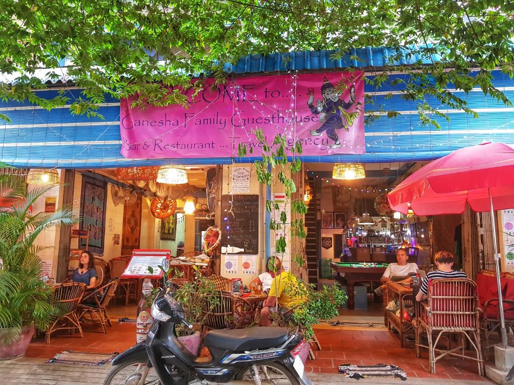 a restaurant with a scooter parked in front of it at Ganesha Hostel in Battambang