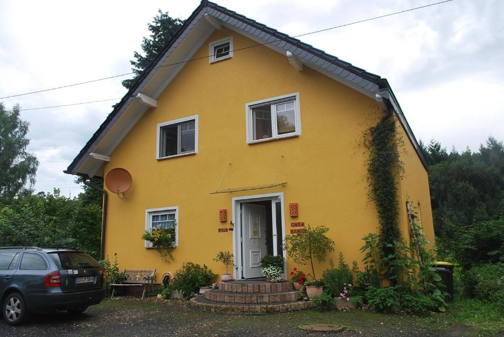 a yellow house with a car parked in front of it at Casa Ramke in Eitorf