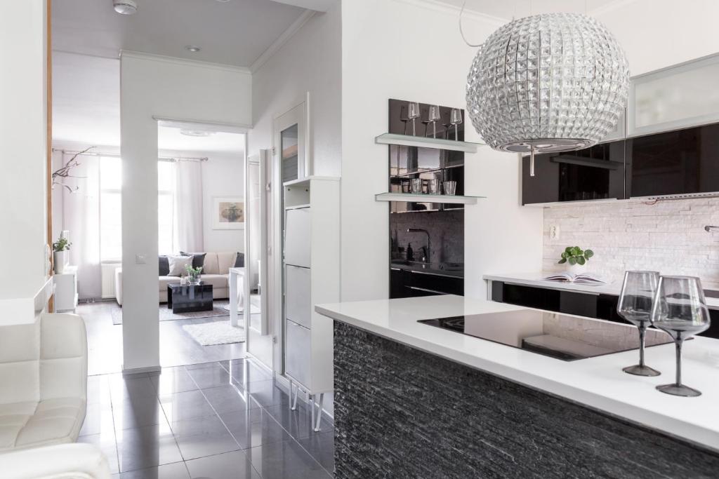 a kitchen with a large chandelier hanging over a counter at Central Alexandra in Tampere