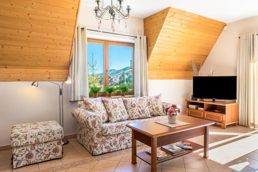 a living room with a couch and a tv at Rent like home - Krzeptówki in Zakopane