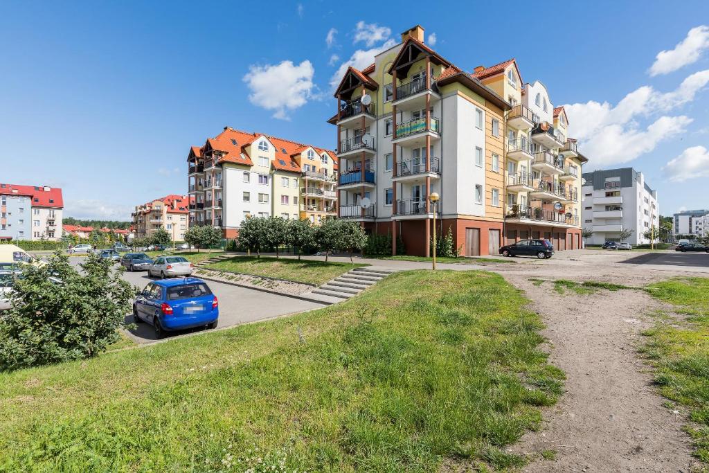 ein Gebäude mit einem blauen Auto auf einem Parkplatz in der Unterkunft Apartments Świnoujście Center by Renters in Świnoujście