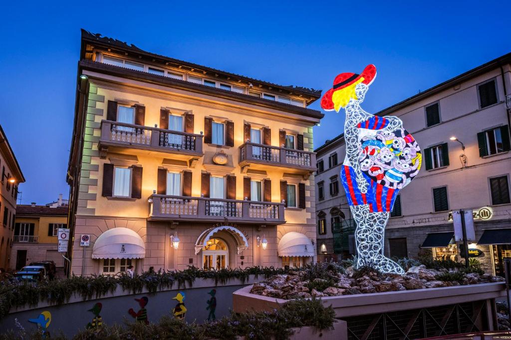 Una statua di un pollo davanti a un edificio di Hotel Armonia a Pontedera
