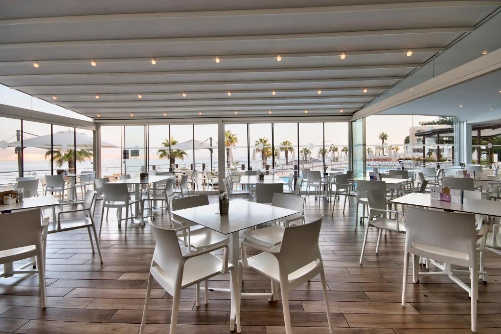 a restaurant with tables and chairs and a view of the ocean at DoubleTree by Hilton Malta in St Paul's Bay