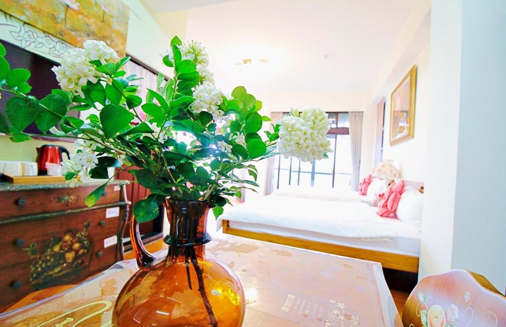 a vase with flowers on a table in a room at My Sweetie B&amp;B in Dongshan