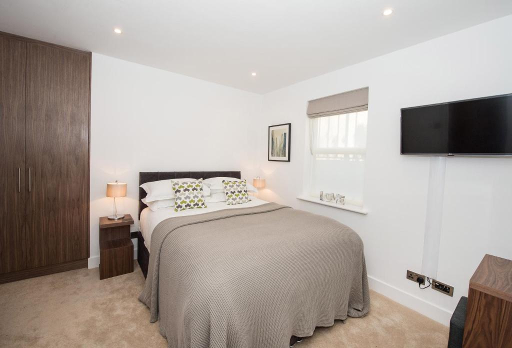 a bedroom with a bed and a flat screen tv at The Windsor - by Harrogate Serviced Apartments in Harrogate