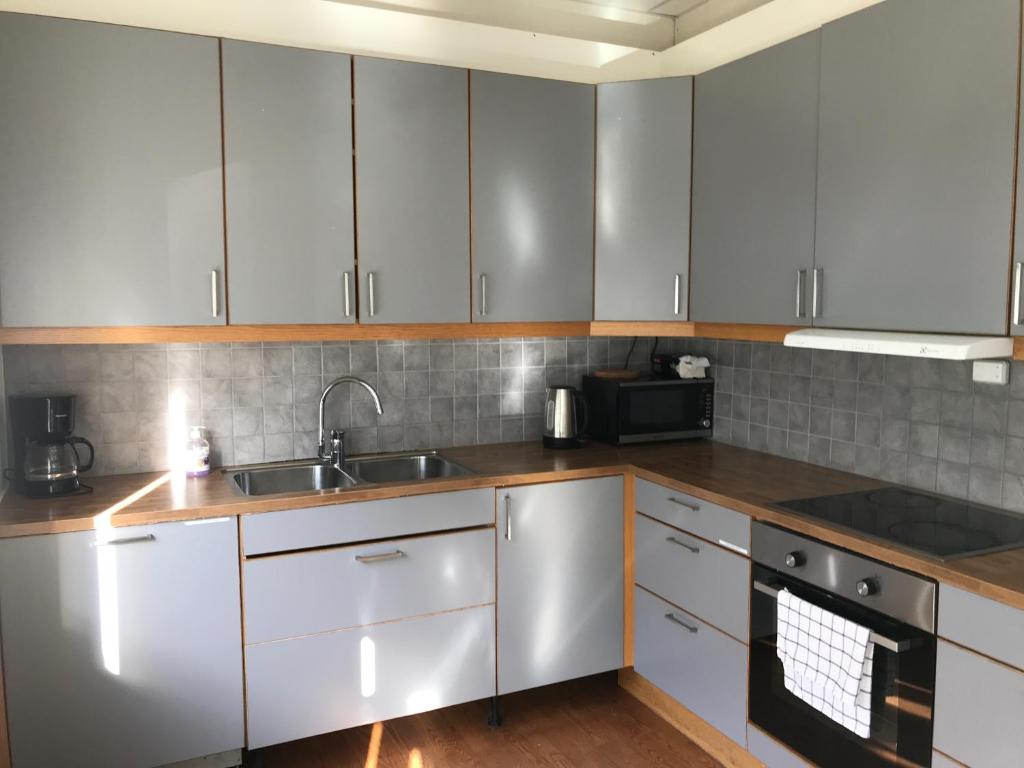 a kitchen with white cabinets and a sink at Guesthouse- Møllegata 39 in Stavanger
