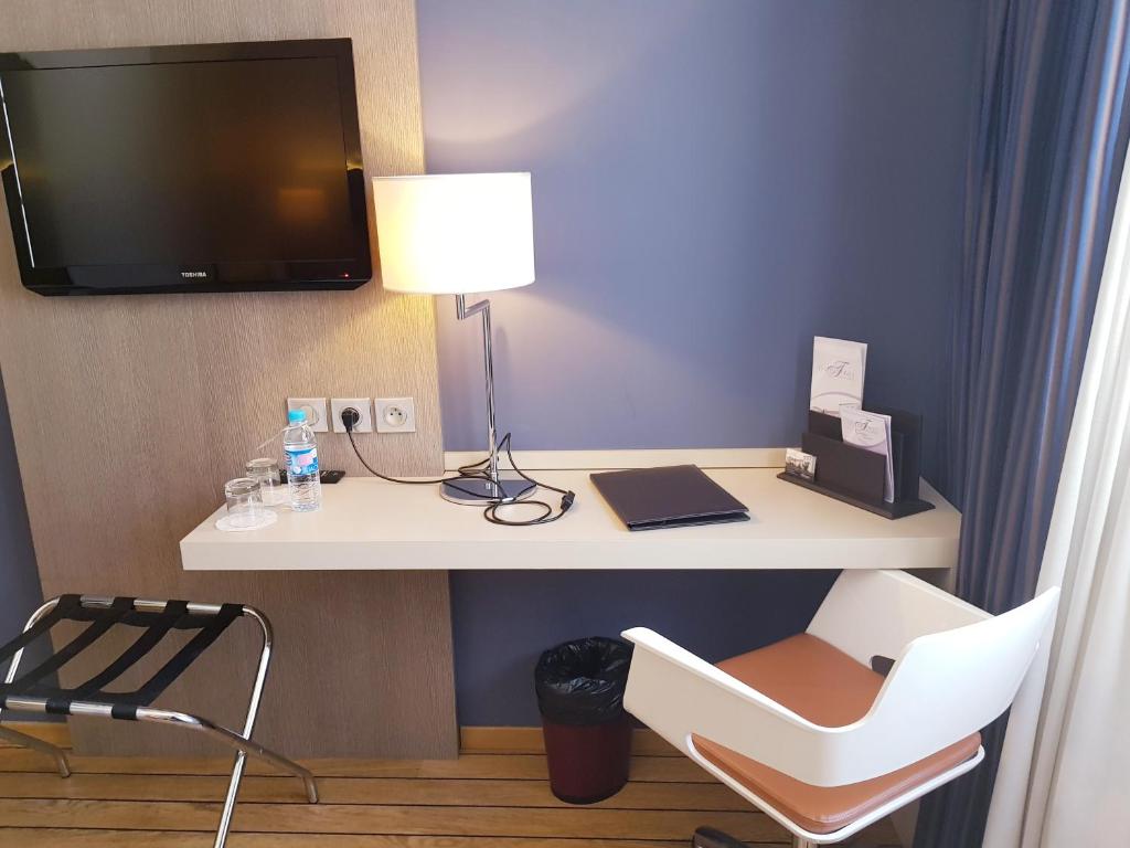 TV a/nebo společenská místnost v ubytování Logis Hôtel Les Tuileries