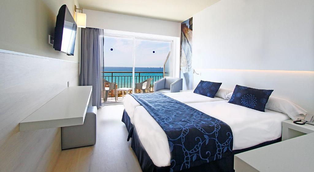 a hotel room with a bed and a view of the ocean at BG Java in Can Pastilla