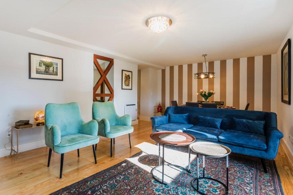 een woonkamer met een blauwe bank en 2 stoelen bij Cathedral Luxury and Spacious in Lissabon