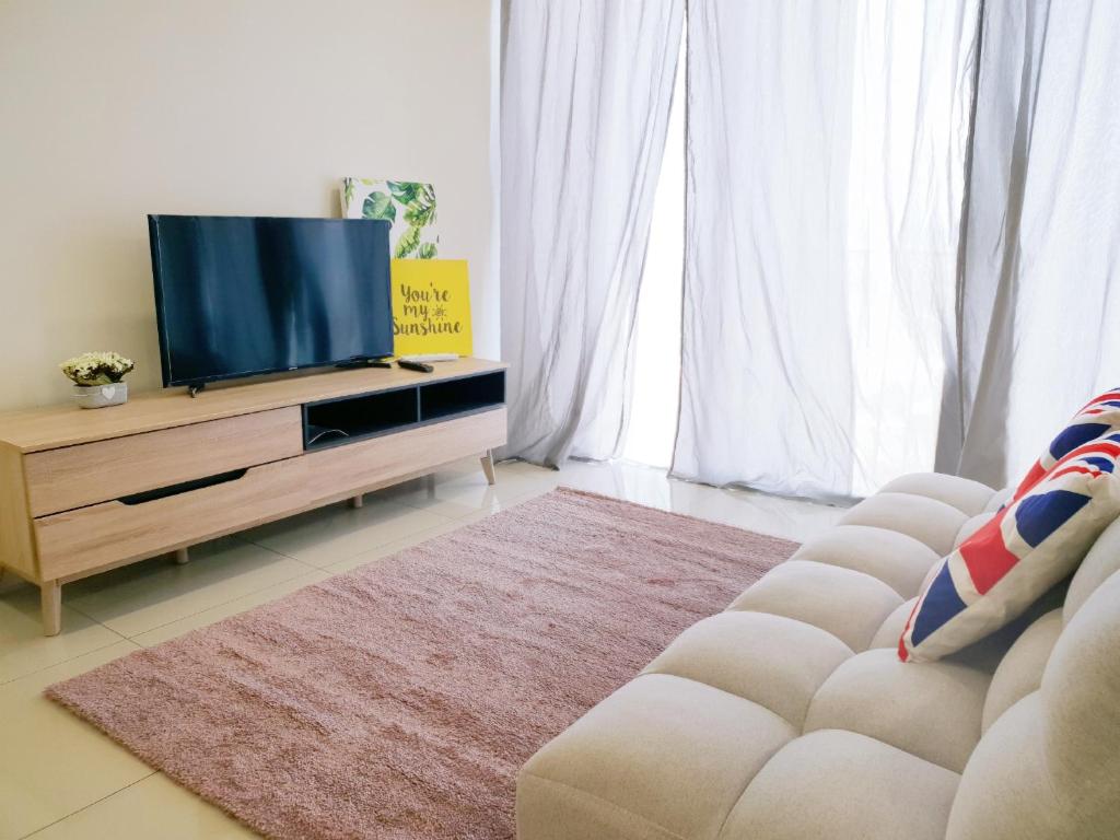a living room with a television and a couch at Trefoil Setia Alam- Simple No 5- Near Setia City Mall & Convention Centre in Setia Alam
