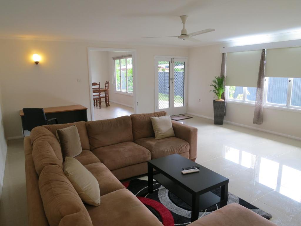 a living room with a couch and a table at Edge Hill Clean & Green Cairns, 7 Minutes from the Airport, 7 Minutes to Cairns CBD & Reef Fleet Terminal in Cairns