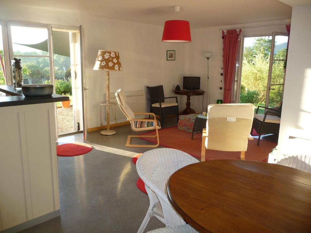 a living room with a table and chairs at Splendide vue Pyrénées, Rez de jardin 2 chambres in Montjoie-en-Couserans