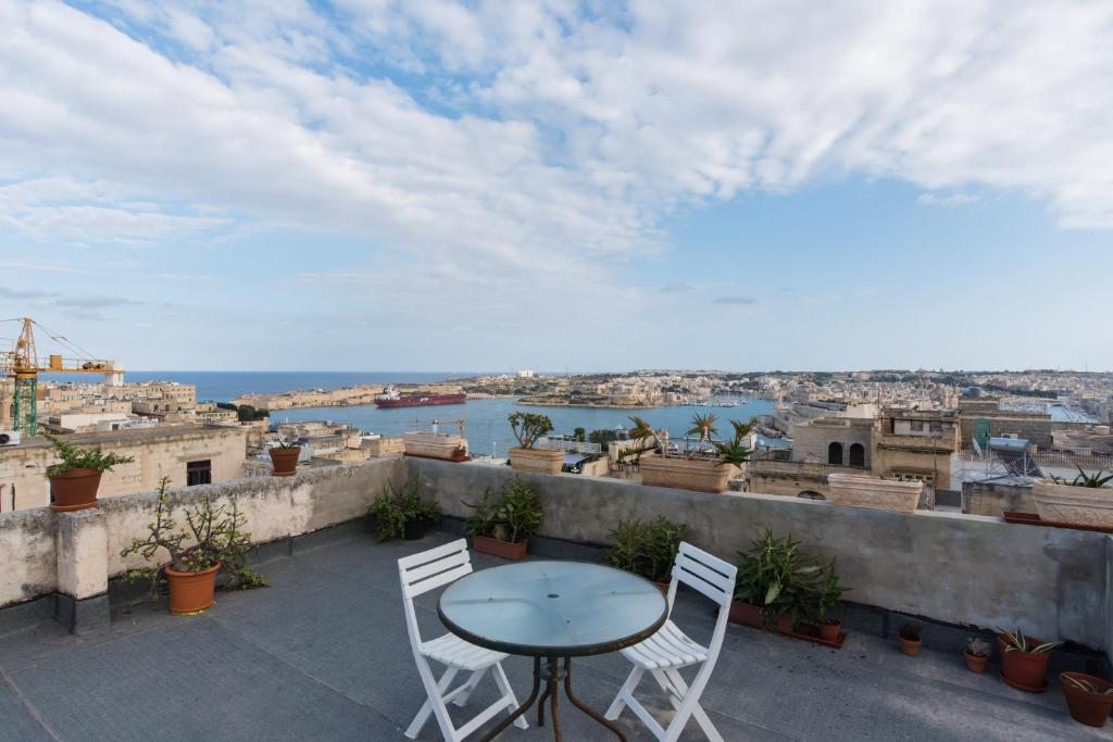 a table and chairs on a balcony with a view of the city at Merkanti Apartments in Valletta