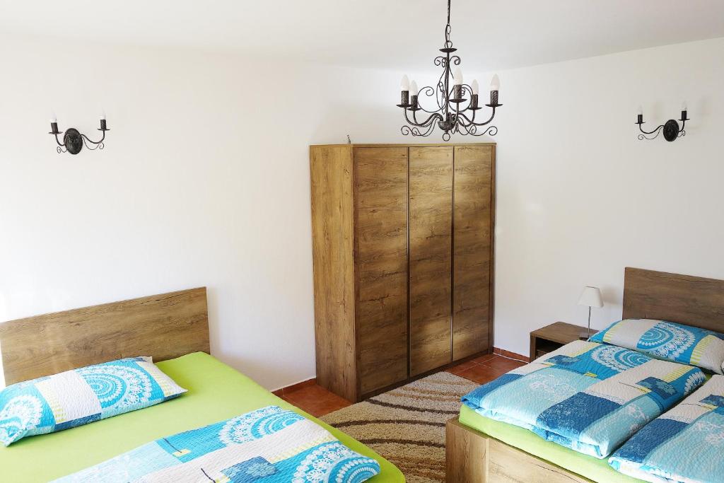 een slaapkamer met 2 bedden en een kroonluchter bij Apartment Marta in Lipno nad Vltavou