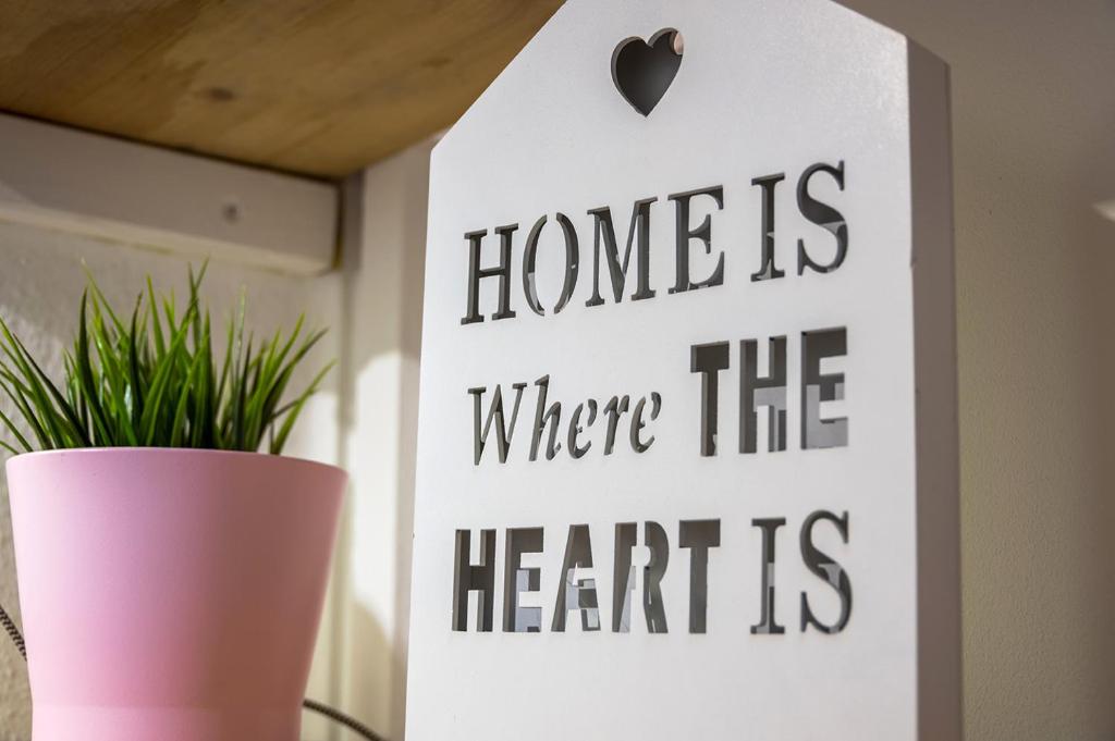 um sinal que diz lar é onde o coração está em Overnight Apartment em Colônia