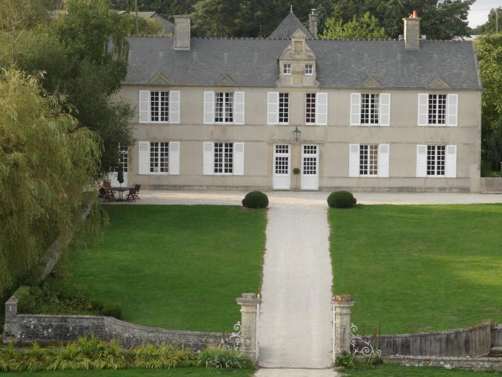 une grande maison avec une pelouse verdoyante et un sentier dans l'établissement Manoir de Conjon, à Crouay