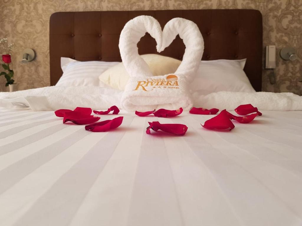 a couple of swans sitting on a bed with roses at Hotel Costa Riviera in Mala