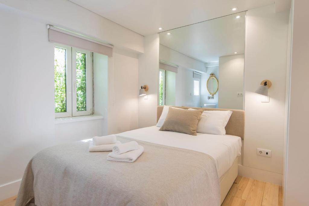 リスボンにあるLovelyStay - Principe Real: modern and comfort!の白いベッドルーム(ベッド1台、タオル2枚付)