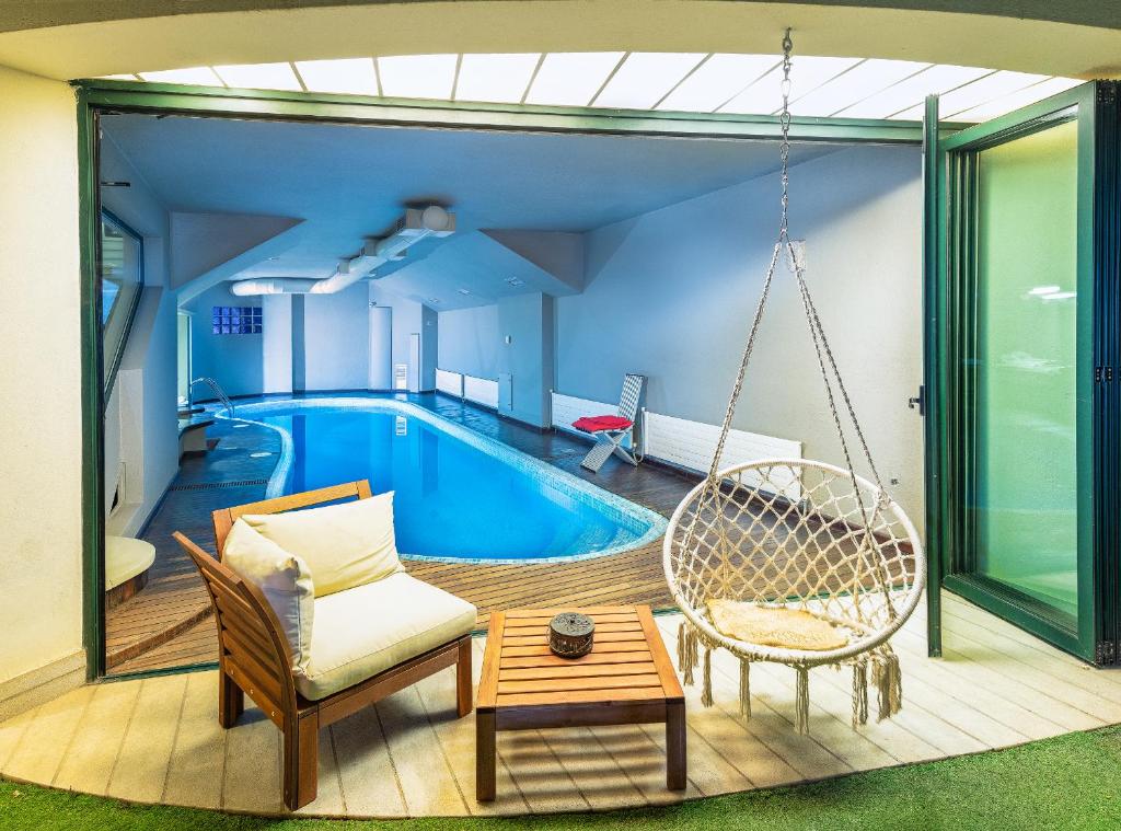 a house with a swing and a swimming pool at Kallimarmaro Residence in Athens