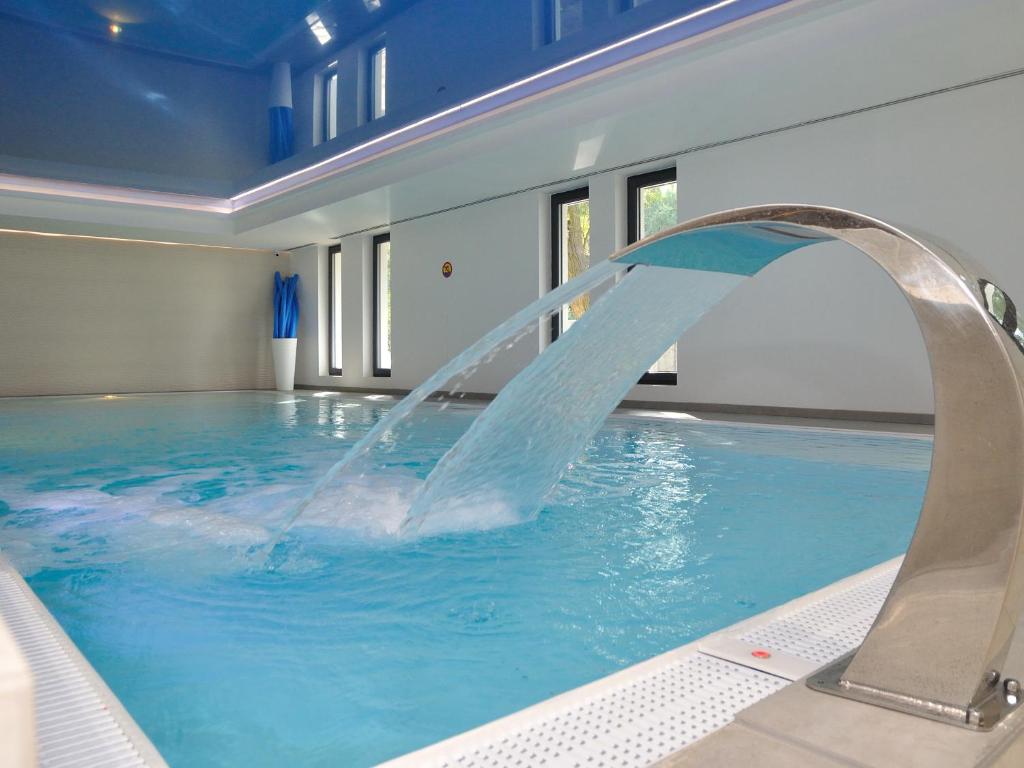 a pool with a water slide in a building at Hotel Hel in Hel