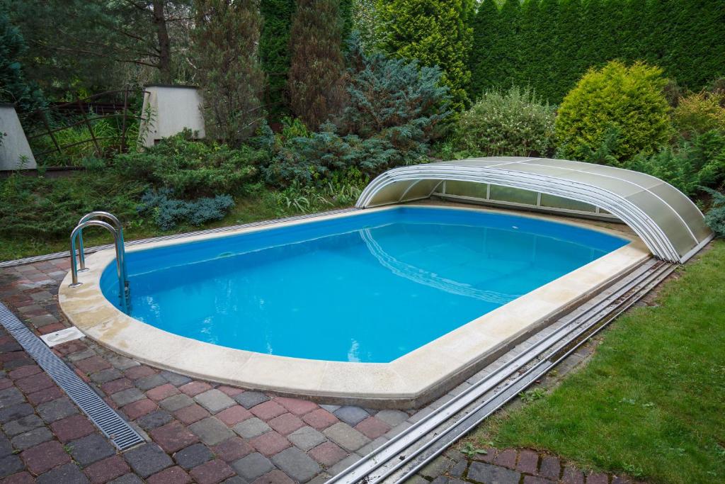 uma piscina com cobertura num quintal em Domina em Vilnius
