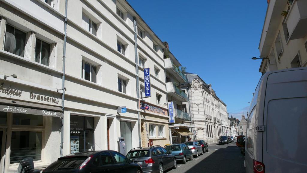 een stadsstraat met auto's geparkeerd voor gebouwen bij Hotel Berthelot in Tours