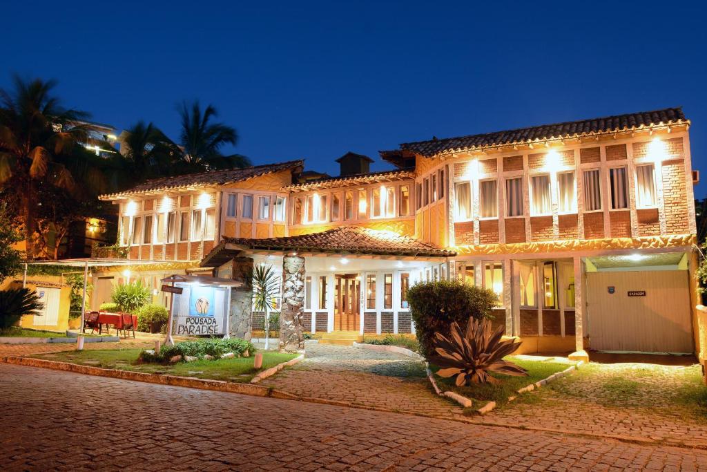 Una casa grande por la noche con luces encendidas. en Pousada New Paradise en Búzios