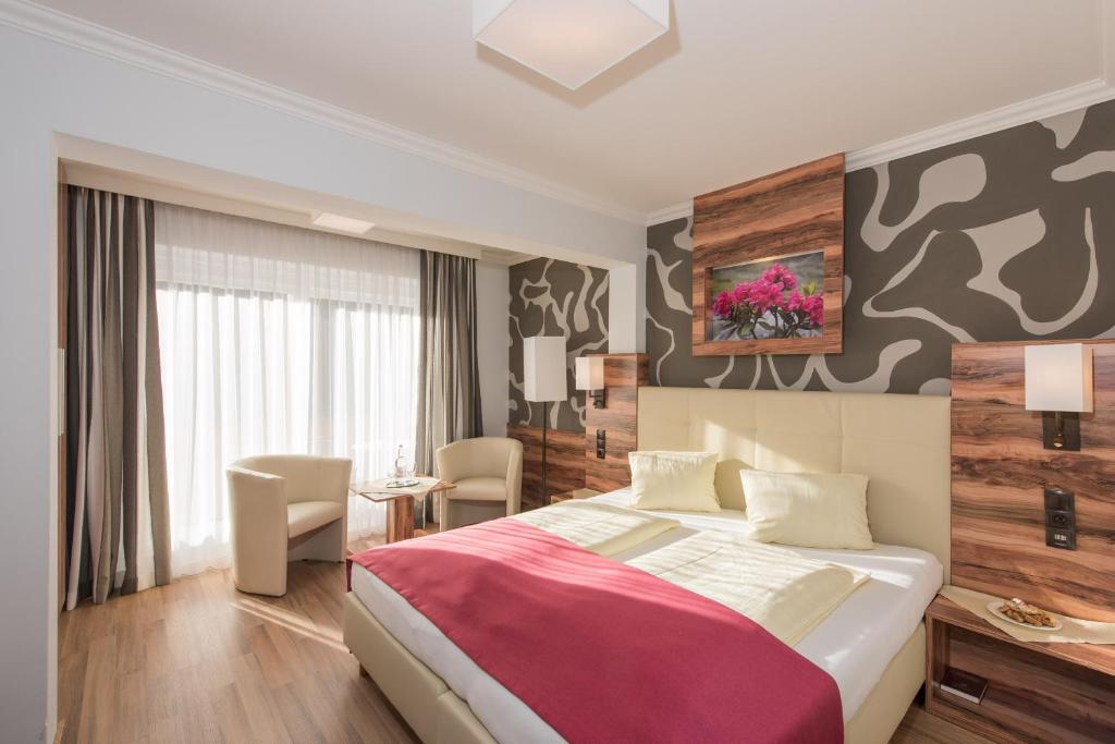 A bed or beds in a room at Genusshotel Almrausch