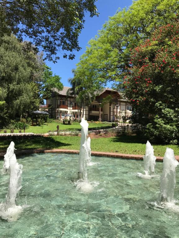 uma fonte na água em frente a uma casa em Hotel Jardins da Colina em Nova Petrópolis