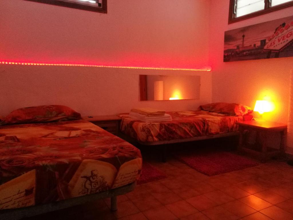 アデへにあるApartment Marina Primaveraの赤い照明付きのベッド2台が備わる客室です。
