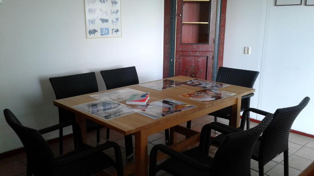 einen Esstisch mit Stühlen und einem Holztisch in der Unterkunft de Mielgong in Boazum