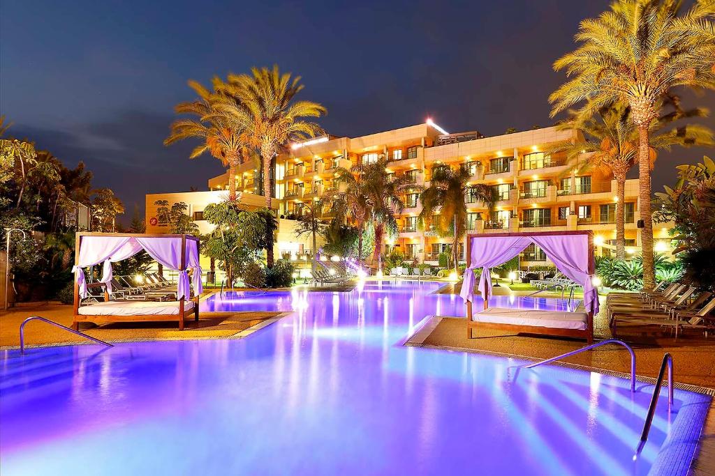 una piscina con luci viola di fronte a un hotel di Exe Estepona Thalasso & Spa- Adults Only a Estepona