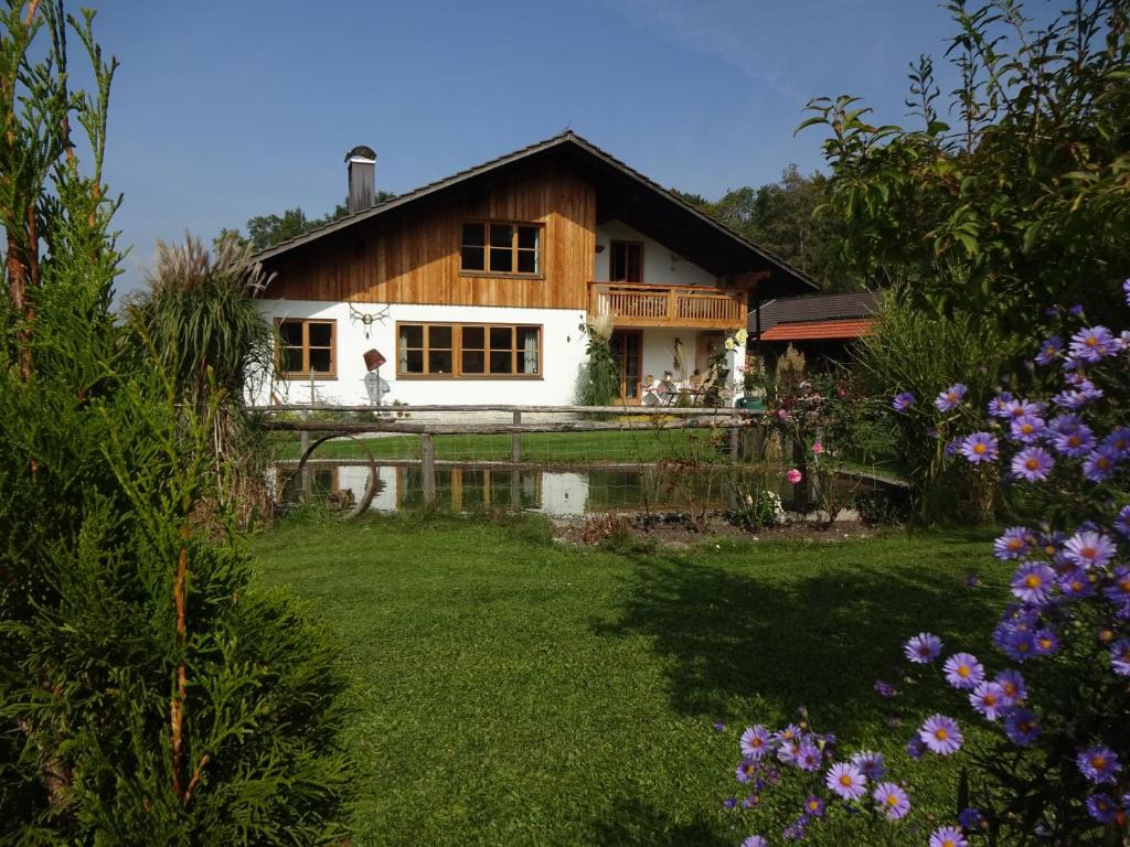 ein Haus inmitten eines Gartens mit Blumen in der Unterkunft Haus Heufelder in Bad Heilbrunn