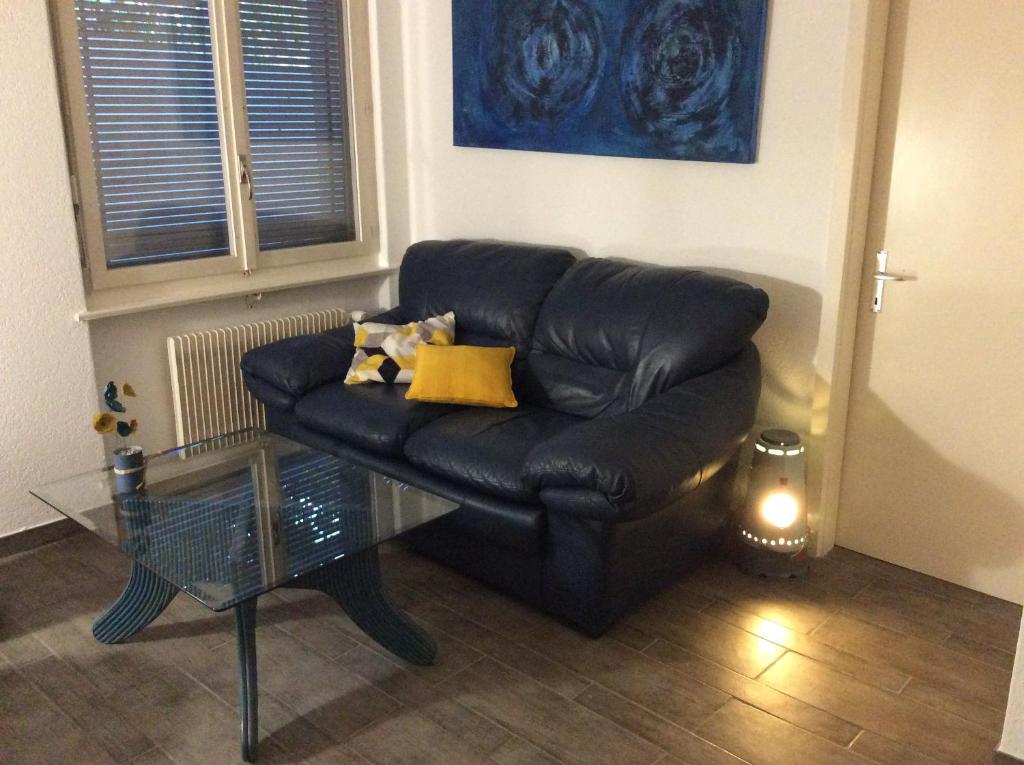un sofá de cuero negro en una sala de estar con mesa de cristal en Le Président 2, en Sierre