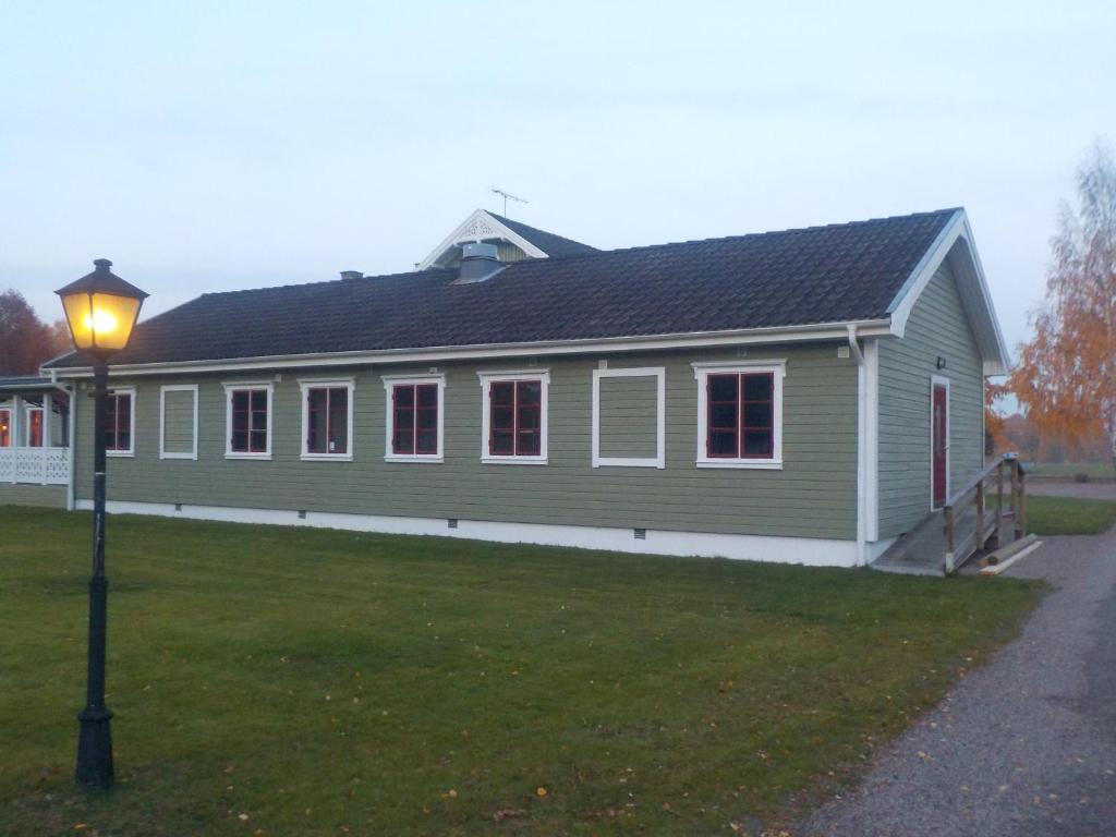 a green building with a street light in front of it at Hagfors Hostel in Råda