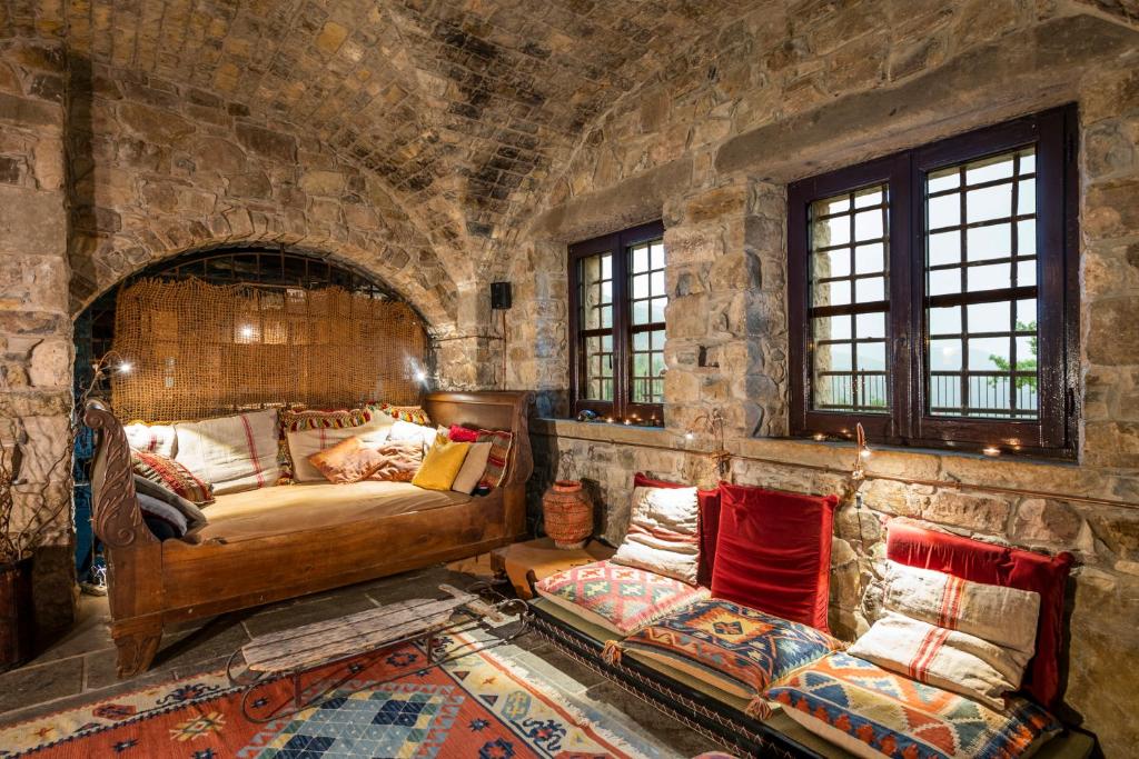 1 dormitorio con 1 cama y 1 sofá en una pared de piedra en Eremito, en Parrano